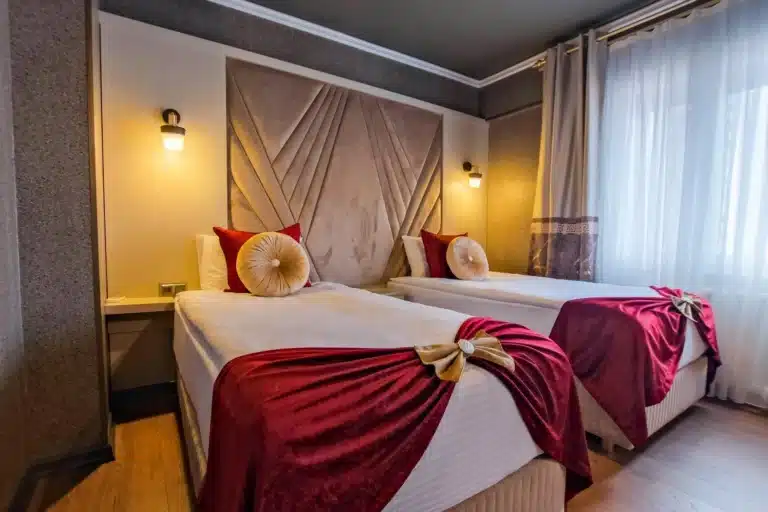 Standart Twin odada iki ayrı yatak ve kırmızı yatak örtüleri