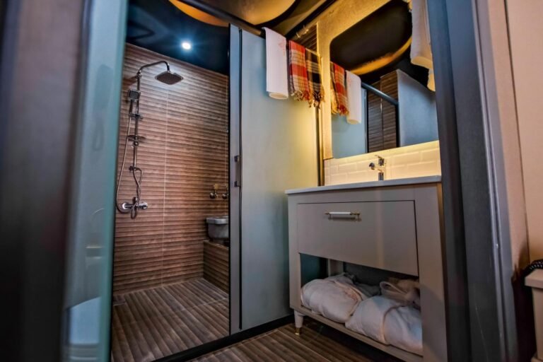 Suit banyosunda lavabo, ayna ve duş bölümü